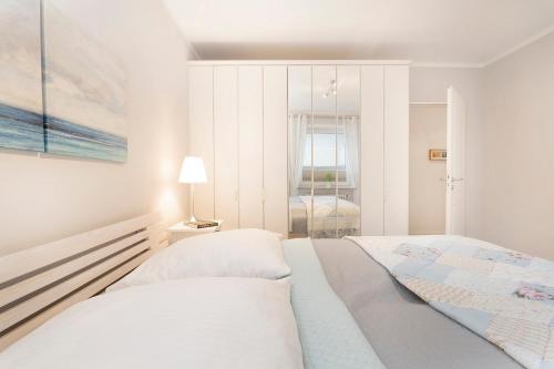 - une chambre blanche avec un lit et une carte murale dans l'établissement Strandfee Wohnung 21, à Grömitz