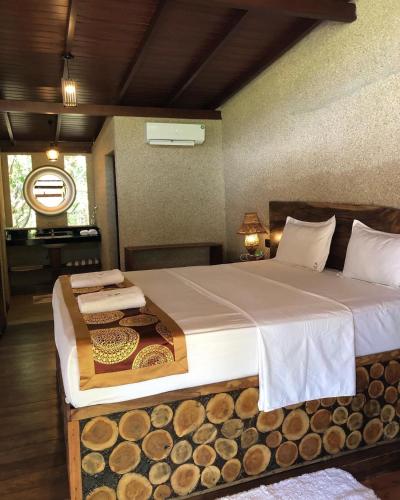 a bedroom with a large bed with logs on it at OHEI in Tangalle