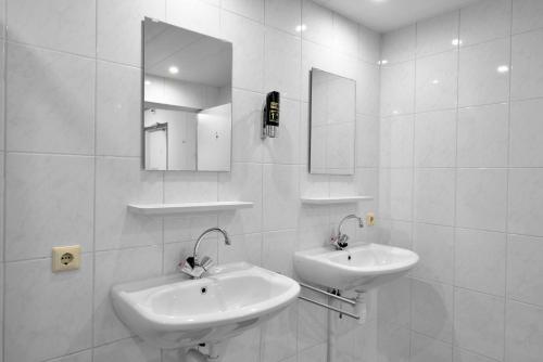 a white bathroom with two sinks and a mirror at Havenzicht in Dinteloord