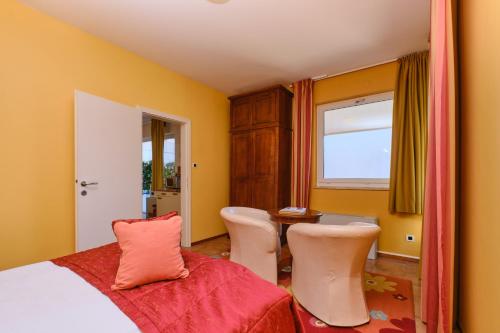 a bedroom with a bed and a table and chairs at Mare Mare Suites in Mali Lošinj