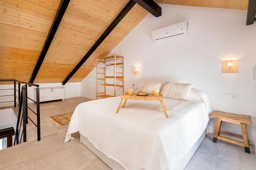 una camera da letto con un letto bianco e un soffitto in legno di BHost - Regina III a Cordoba