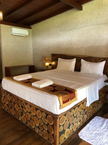 a bedroom with a large bed with a wooden headboard at OHEI in Tangalle