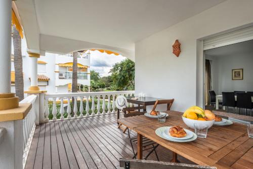 a balcony with a wooden table with fruit on it at Apartamento Dama de Noche l in Marbella