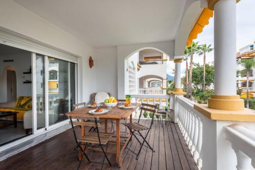 a balcony with a wooden table and chairs at Apartamento Dama de Noche l in Marbella