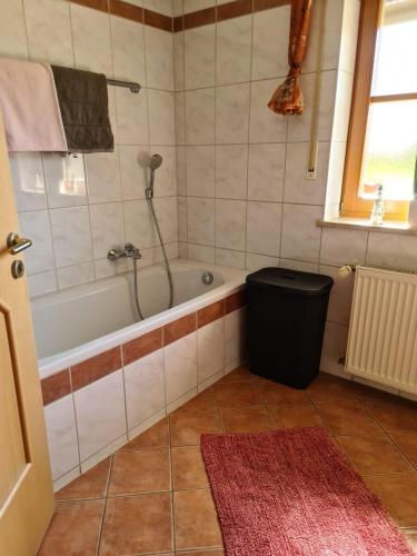 a bathroom with a bath tub and a window at Ferienwohnung HOAMAT Schmalzreich Andrea in Lam