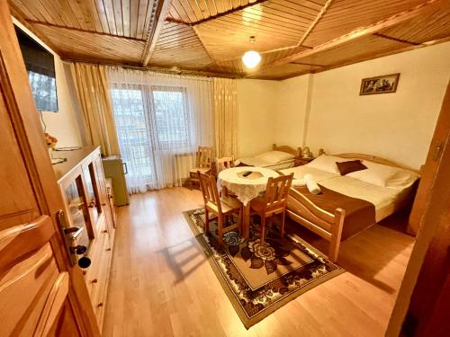 a bedroom with a bed and a table and chairs at Apartamenty i pokoje Borysek in Białka Tatrzanska