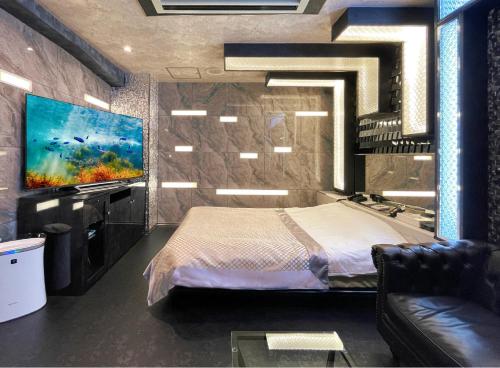 a bedroom with a bed and a flat screen tv at Hotel Gran Villa in Tokyo