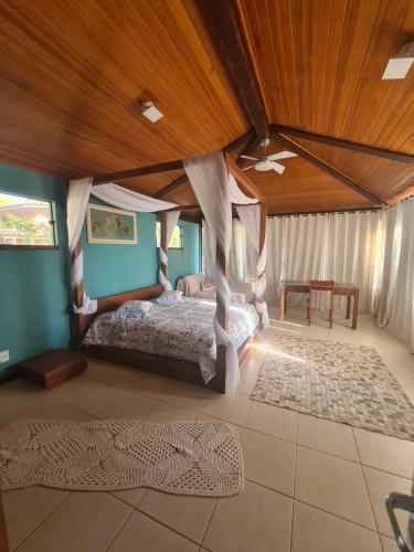 una camera con letto e soffitto in legno di Casa Ferradura com hidro,piscina e 500 metros da praia a Búzios