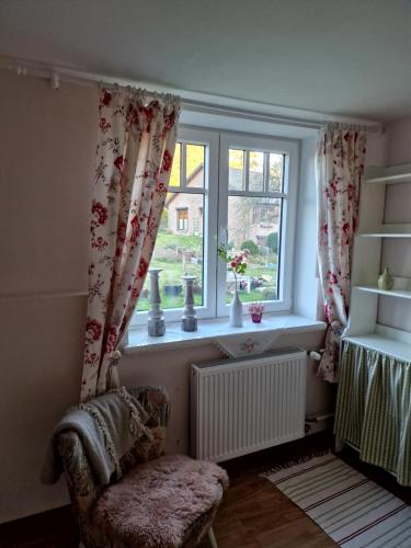 a window with curtains and a chair in a room at Haus Dany in Raeren
