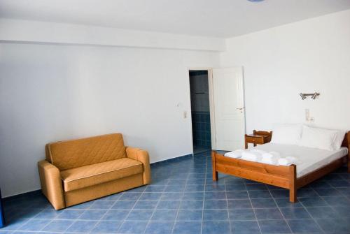 a bedroom with a couch and a bed and a chair at Pantheon Studios in Léntas