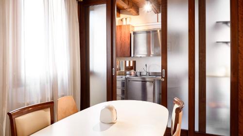 a kitchen with a white table and a refrigerator at Casanova Fourrooms in Venice