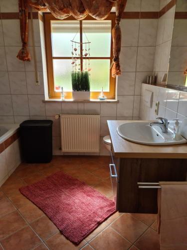 a bathroom with a sink and a toilet and a window at Ferienwohnung HOAMAT Schmalzreich Andrea in Lam