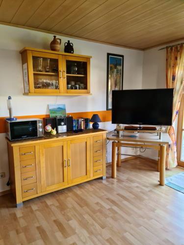 a living room with a tv and a table at Ferienwohnung HOAMAT Schmalzreich Andrea in Lam