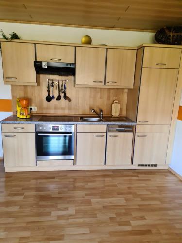 a kitchen with stainless steel appliances and wooden cabinets at Ferienwohnung HOAMAT Schmalzreich Andrea in Lam