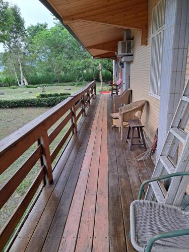 a wooden deck with benches on a house at Green Forest Homestay in Nung-hui-ti