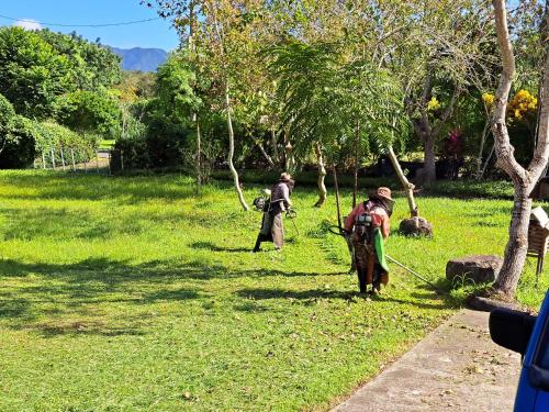 Um par de homens a caminhar por um campo relvado em Green Forest Homestay em Nung-hui-ti