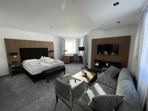 a hotel room with a couch and a bed at Hotel Aaritz in Selva di Val Gardena