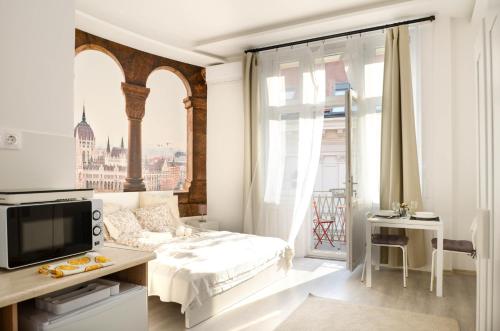 um quarto branco com uma cama e uma grande janela em Papnövelde Royal Inn @Inner City em Budapeste
