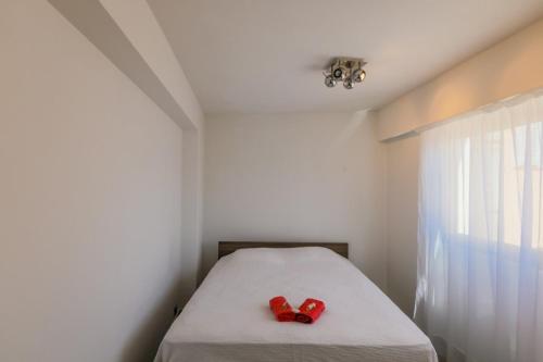 un lit avec une paire de chaussures rouges assises sur lui dans l'établissement SUEDE 4 AP4210 By Riviera Holiday Homes, à Nice