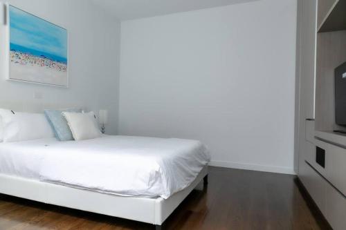 a bedroom with a white bed and a television at 124 Modern 2Bed (21sq) in heart of Sorrento in Sorrento
