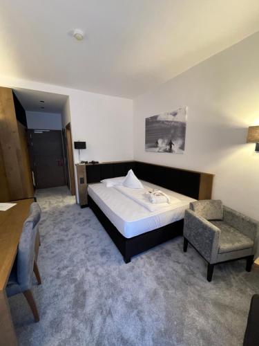 a hotel room with a bed and a chair at Hotel Aaritz in Selva di Val Gardena