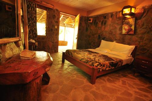 a bedroom with a bed and a table in a room at Naiberi River Campsite & Resort in Eldoret