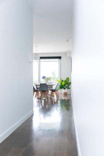 a white living room with a table and chairs at 124 Modern 2Bed (21sq) in heart of Sorrento in Sorrento