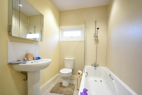 a bathroom with a sink and a toilet and a bath tub at Rose Cottage Elsdon in Elsdon