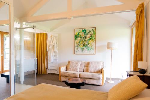 a living room with a bed and a couch at La Maison des Bois in Bagnoles de l'Orne