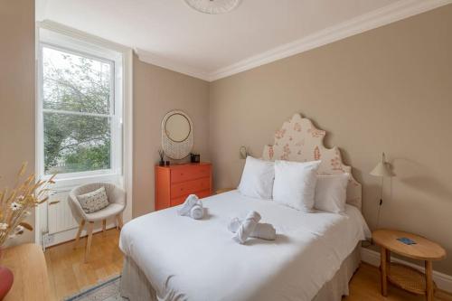 een slaapkamer met een wit bed met twee teddyberen erop bij Stylish Central Apartment with Parking - Garden and Workspace in Bath