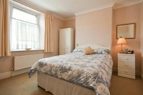 a bedroom with a bed and a window at Seaview Cottage Amble in Amble