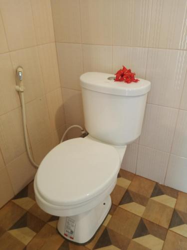 a white toilet with a red bow on top of it at Mookies Bungalows in Koh Mook