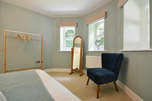 a bedroom with a bed and a blue chair at The Lodge Alnwick in Alnwick