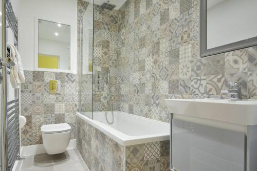a bathroom with a tub and a sink and a toilet at The Lodge Alnwick in Alnwick