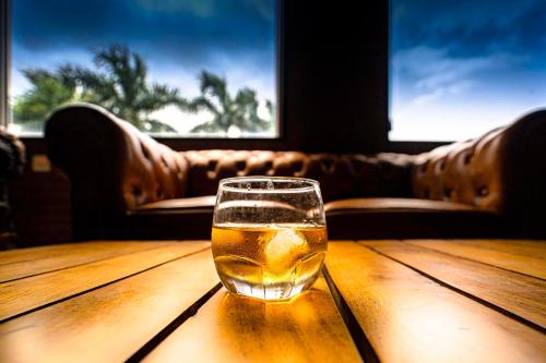 a glass of beer sitting on a wooden table at Hotel Chandrawati Palace in Ābu Road