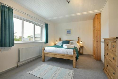 a bedroom with a bed and a window at The Burgage House in Warkworth