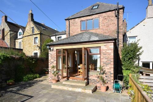 a extension to a brick house with sliding glass doors at The Burgage House in Warkworth