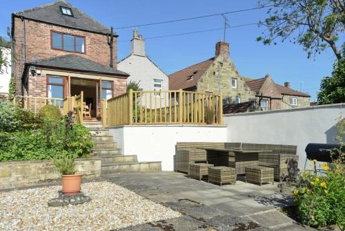 a house with a porch and a fire place in a yard at The Burgage House in Warkworth