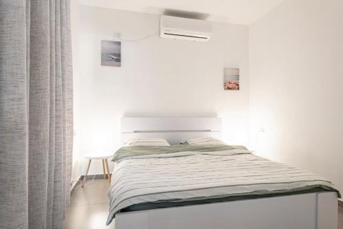 a bed in a white room with a bedvisor at Abbas BayView Apartment in Haifa
