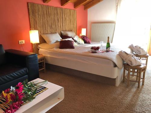 a bedroom with a bed with a table and a couch at Hotel Bamboo in Coldrano