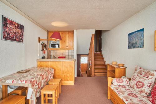 un petit salon avec un canapé et une cuisine dans l'établissement Appartement au pied des pistes, à Saint-Martin-de-Belleville