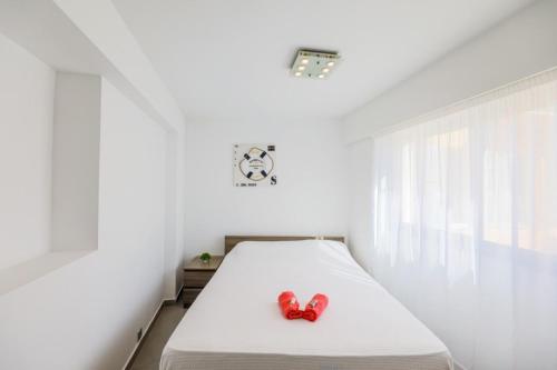 - un lit blanc avec deux chaussures rouges dans l'établissement SUEDE 3 AP4209 By Riviera Holiday Homes, à Nice