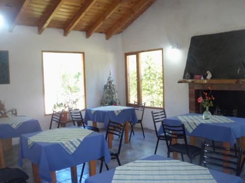 a classroom with blue tables and chairs and a chalkboard at Hosteria Tres Picos in Lago Puelo