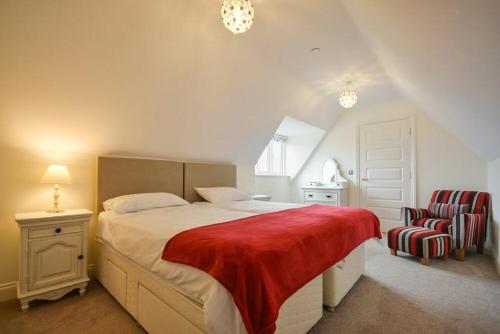 a bedroom with a large bed with a red blanket at Two Castles in Bamburgh