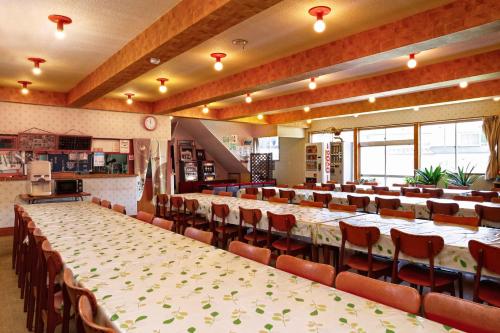 un gran salón de banquetes con mesas y sillas. en Lodge Shosen, en Otari