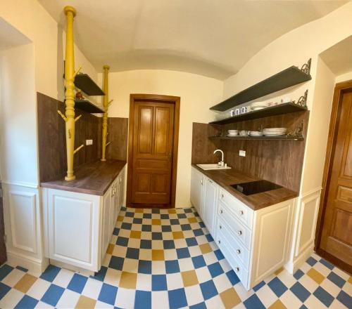 uma cozinha com um lavatório e um piso em xadrez em Segesdy Villa em Balatonalmádi