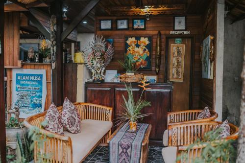 a table and chairs in a restaurant with a table and pillows at Alam Nusa Bungalow Huts & Spa in Nusa Lembongan