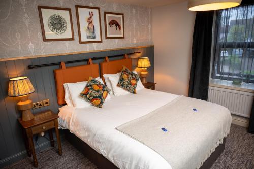 - une chambre avec un grand lit blanc et des oreillers dans l'établissement Green Man by Chef & Brewer Collection, à Harlow
