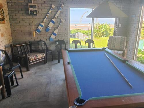 - un billard dans une pièce avec des chaises dans l'établissement Driftwood Chalets, à Tugela Mouth