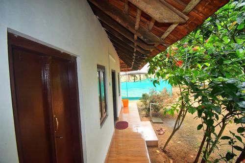 an open door to a house with a view of a pool at Munroe Inn Homestay in Kollam